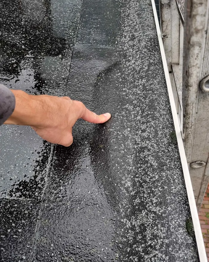 Dakwerker van Den Dekker controleert de naden van een plat dak